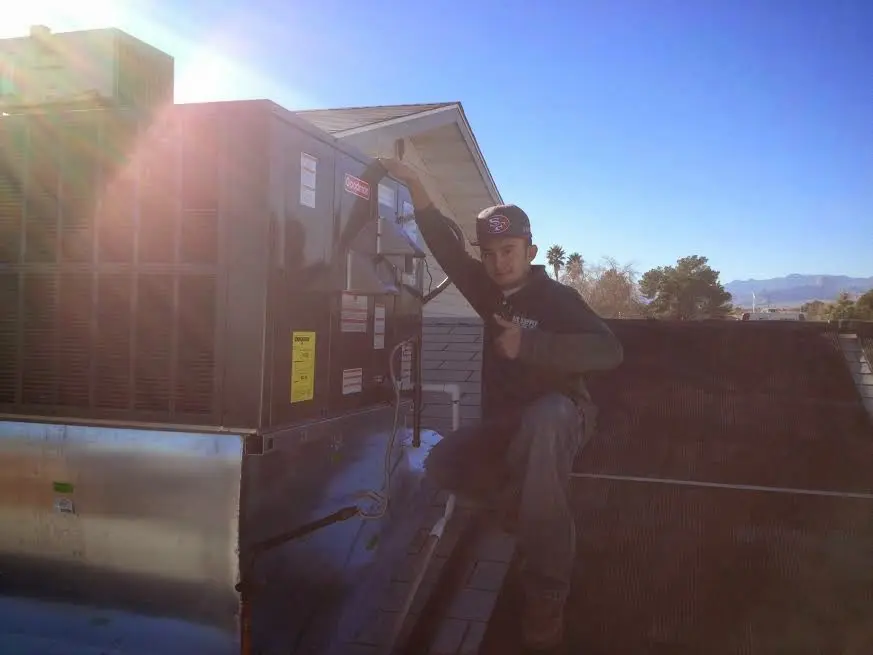 HVAC technician performing Air Duct Repair on a rooftop unit in Carson